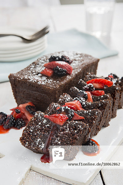 Geschnittener Schokoladenkuchen mit Erdbeeren und Brombeeren