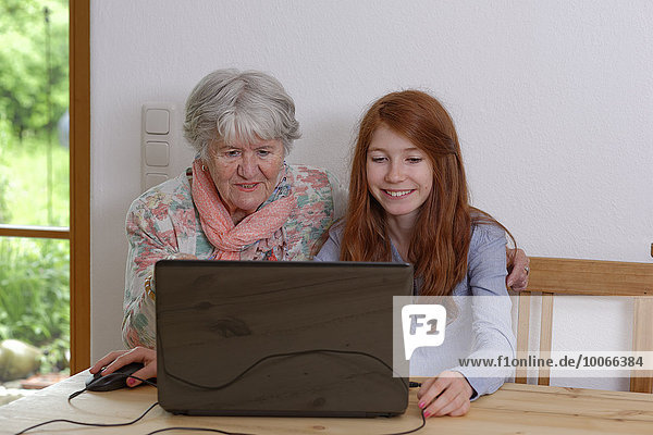 Granddaughter and grandmother using laptop  Bavaria  Germany  Europe