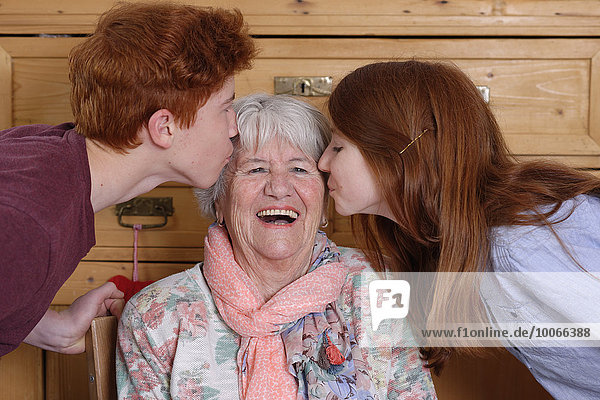 Großmutter bekommt einen Kuss von ihren Enkelkindern  Bayern  Deutschland  Europa