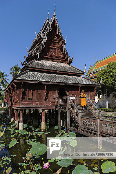 Mönch vor dem Wat Thung Si Mueang  Klosterbibliothek  Lotusteich  Muang  Ubon Ratchathani  Isan  Isaan  Thailand  Asien