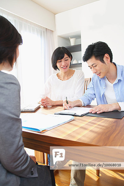 Young Japanese couple consulting with financial planner