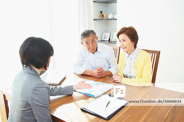 Senior Japanese couple consulting with financial planner