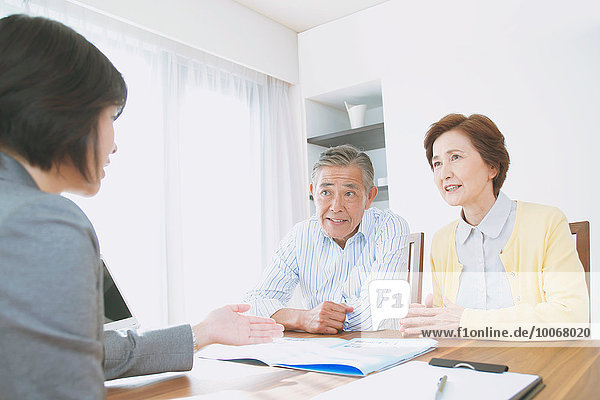 Senior Japanese couple consulting with financial planner