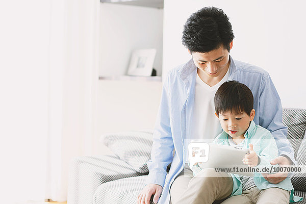 Japanese father and son on the sofa with tablet
