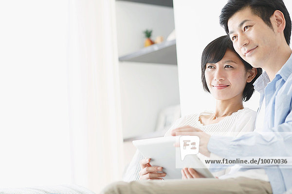 Japanese couple on the sofa with tablet