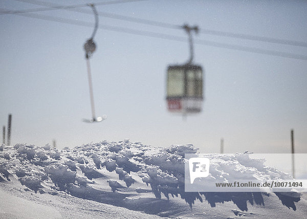 Schneebedeckter Berg mit Luftseilbahn im Hintergrund