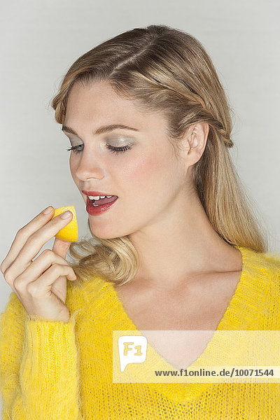 Nahaufnahme einer Frau beim Essen einer Orangenscheibe