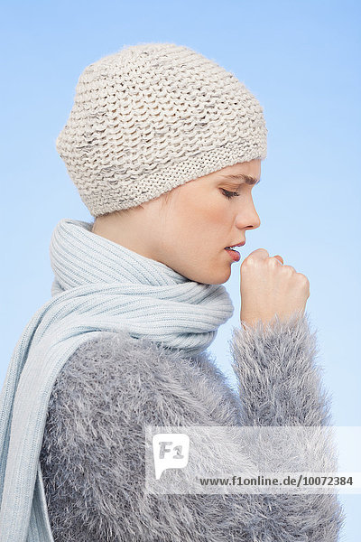 Woman in knitted hat and coughing