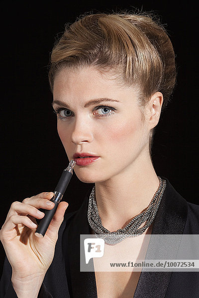 Beautiful woman smoking electronic cigarette