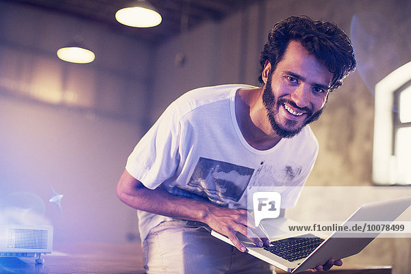 Portrait begeisterter Gelegenheitsunternehmer mit Laptop im Büro