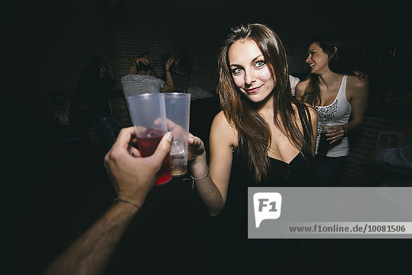 Friends toasting and drinking in nightclub