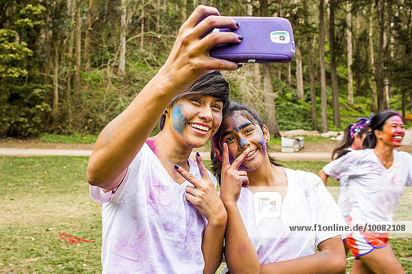 Friends taking selfie covered in pigment powder