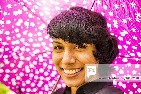 Frau lächeln Regenschirm Schirm Hispanier halten pink