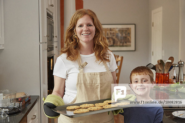 Caucasian mother and son baking cookies in kitchen