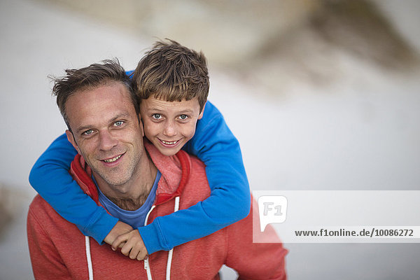 Caucasian father carrying son piggyback outdoors