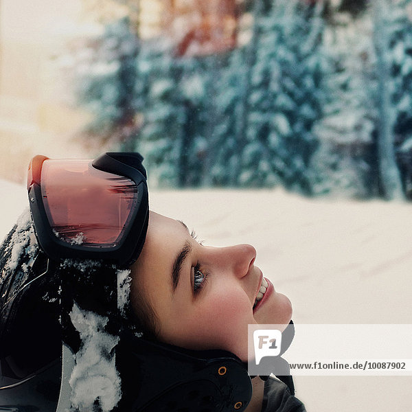 Caucasian snowboarder wearing goggles and helmet looking up, Caucasian snowboarder wearing goggles and helmet looking up
