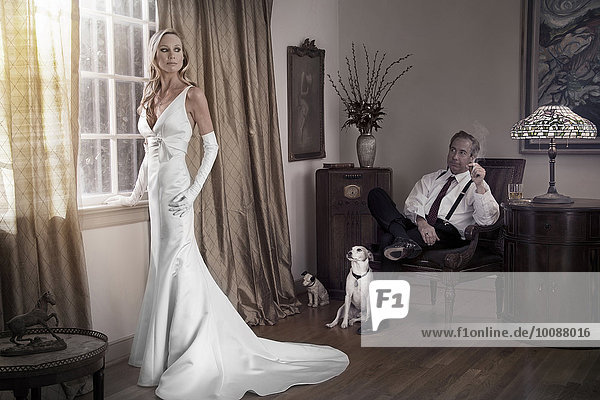 Caucasian bride and groom in study with dogs