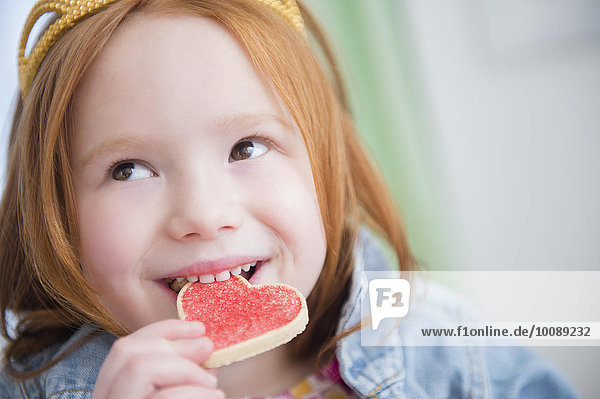Europäer essen essend isst Mädchen Keks herzförmig Herz