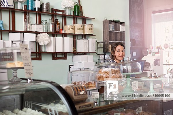 Bakery owner standing behind counter of vegan  allergy-friendly bakery