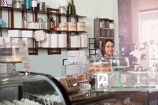 Bäckereibesitzer steht hinter der Theke einer veganen  allergikerfreundlichen Bäckerei.