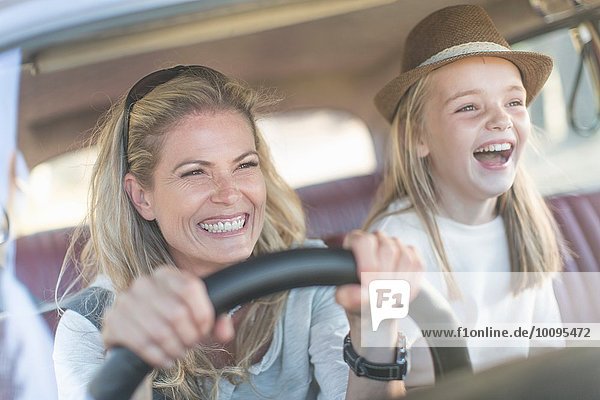 Mother and daughter in car together  smiling