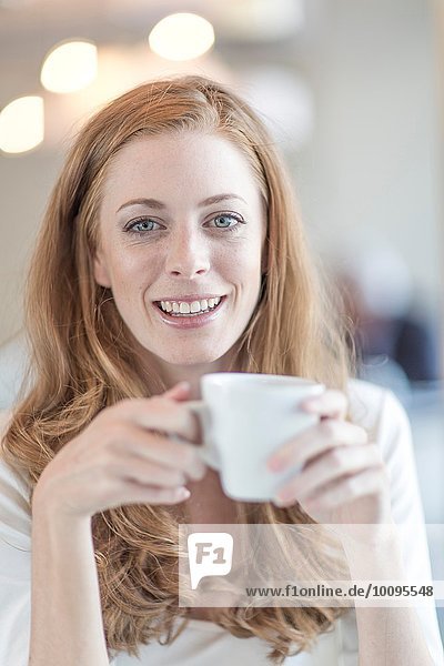 Porträt einer jungen Geschäftsfrau beim Kaffeetrinken