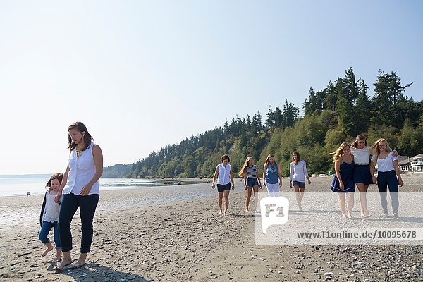 Three generation female family strolling on beach