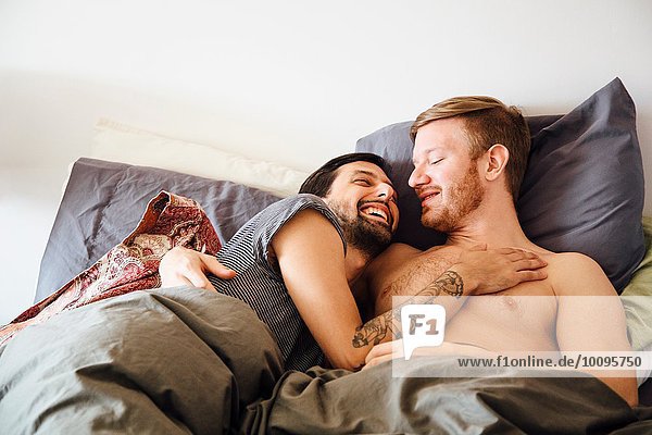 Männliches Paar im Bett  umarmend  von Angesicht zu Angesicht