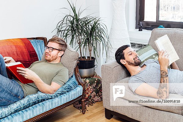 Male couple reading at home