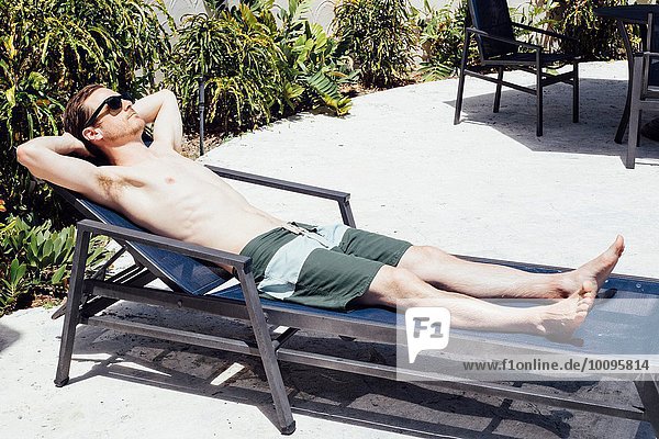 Mittlerer Erwachsener Mann beim Sonnenbaden auf der Liege  Miami Beach  Florida  USA