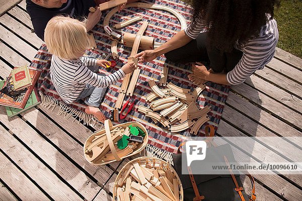 Mutter und Sohn spielen mit Holzspielzeugeisenbahn hoher Winkel