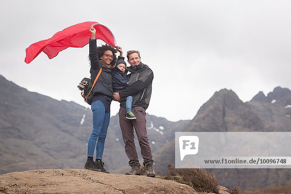 Familie mit roter Flagge in den Bergen  Fairy Pools  Isle of Skye  Hebrides  Schottland