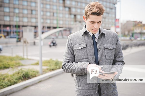 Portrait eines jungen Geschäftsmannes mit digitalem Tablett.