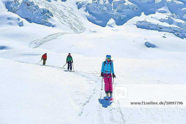 Reihe von drei erwachsenen Skifahrern  die das Mont-Blanc-Massiv hinunterfahren  Graian Alps  Frankreich
