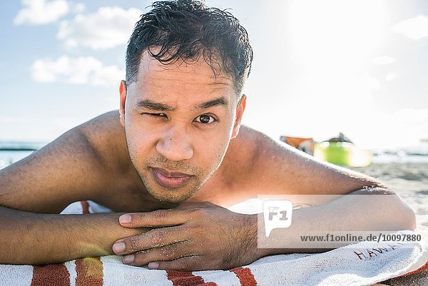 Portrait eines jungen Mannes beim Sonnenbaden am Waikiki Beach  Hawaii  USA