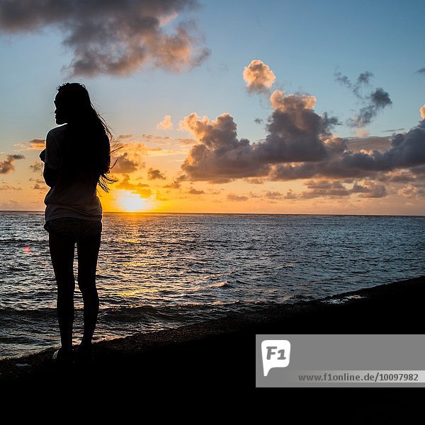 Silhouette of young woman watching sunrise  Kaaawa beach  Oahu  Hawaii  USA