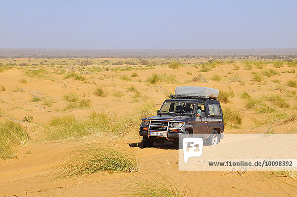 SUV with roof tent on the road in the desert  route from Atar to Tidjikja  Adrar region  Mauritania  Africa