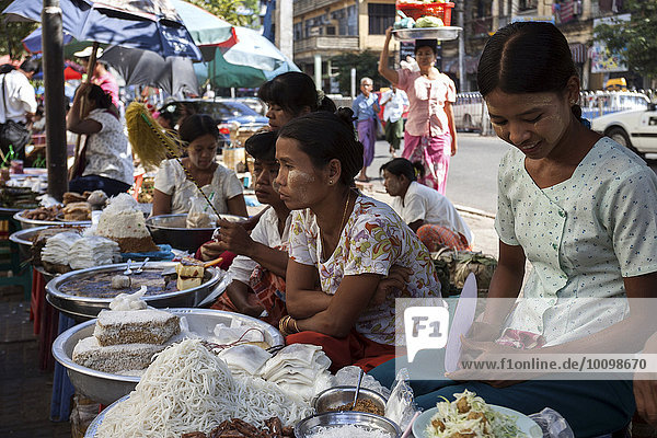 Frauen verkaufen Essen an einem Straßenstand  Yangon  Myanmar  Asien