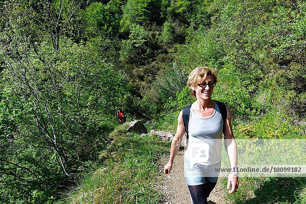 Mature female hiker hiking up hillside path