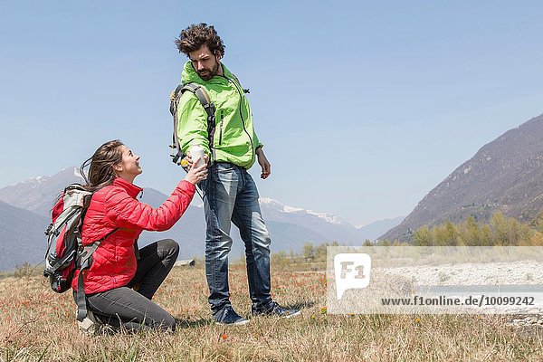 Young female hiker handing water bottle to boyfriend  Vogogna  Verbania  Piemonte  Italy