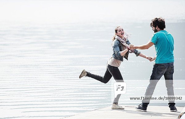 Young couple fooling around on pier at Lake Mergozzo  Verbania  Piemonte  Italy
