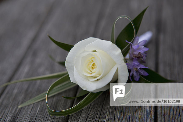 Eine Boutonniere  Knopflochblume  weiße Rose.