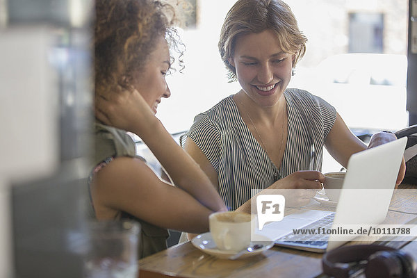 Geschäftsfrauen mit Kaffee arbeiten am Laptop im Cafe