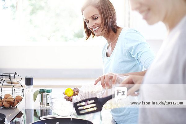 Smiling women cooking in kitchen