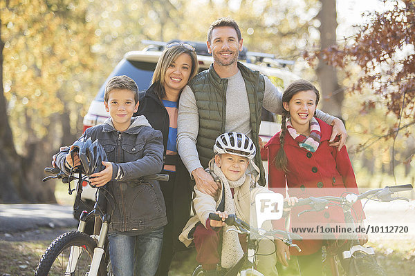 Portrait smiling family with bicycles outdoors