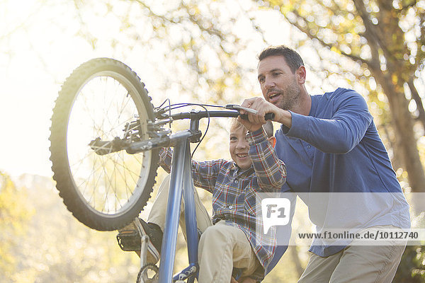 unterrichten Menschlicher Vater Sohn Fahrrad Rad nur auf dem Hinterrad fahren