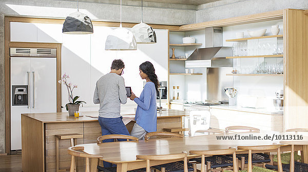 Couple using digital tablet in kitchen