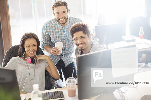 Portrait smiling creative business people with coffee and headphones in office