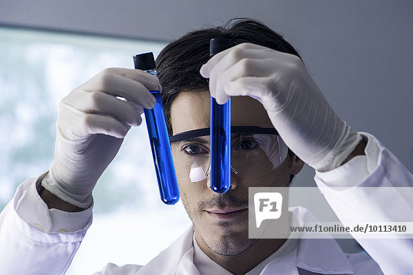 Forscher untersuchen Reagenzgläser mit blauer Flüssigkeit im Labor