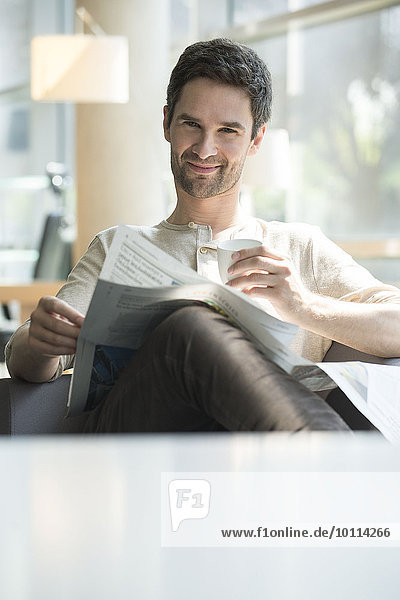 Mann entspannt sich bei Kaffee und Zeitung